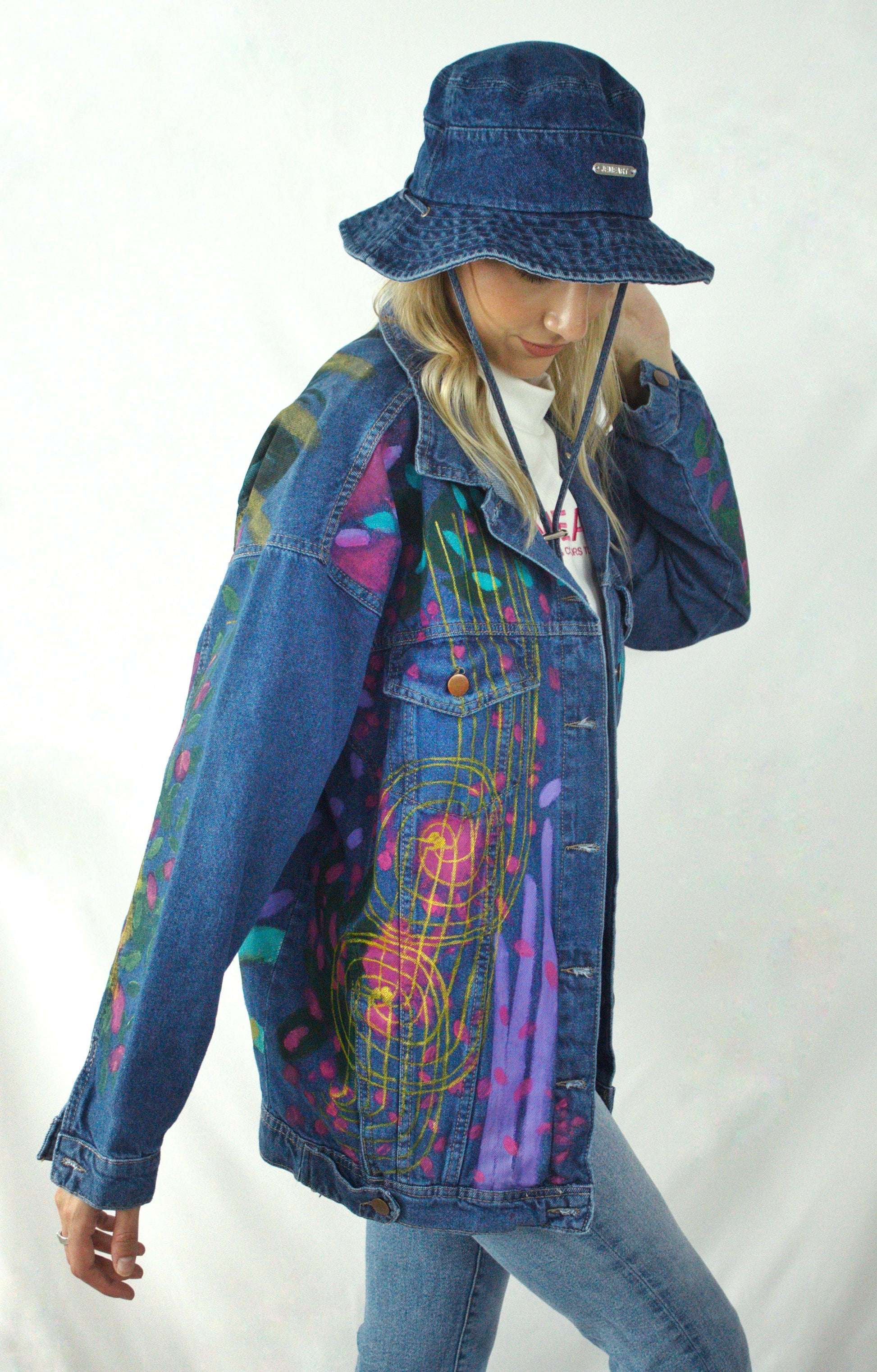 Painted denim jacket showcasing a tropical-inspired leopard design with fuchsia, lilac, gold, and turquoise tones.