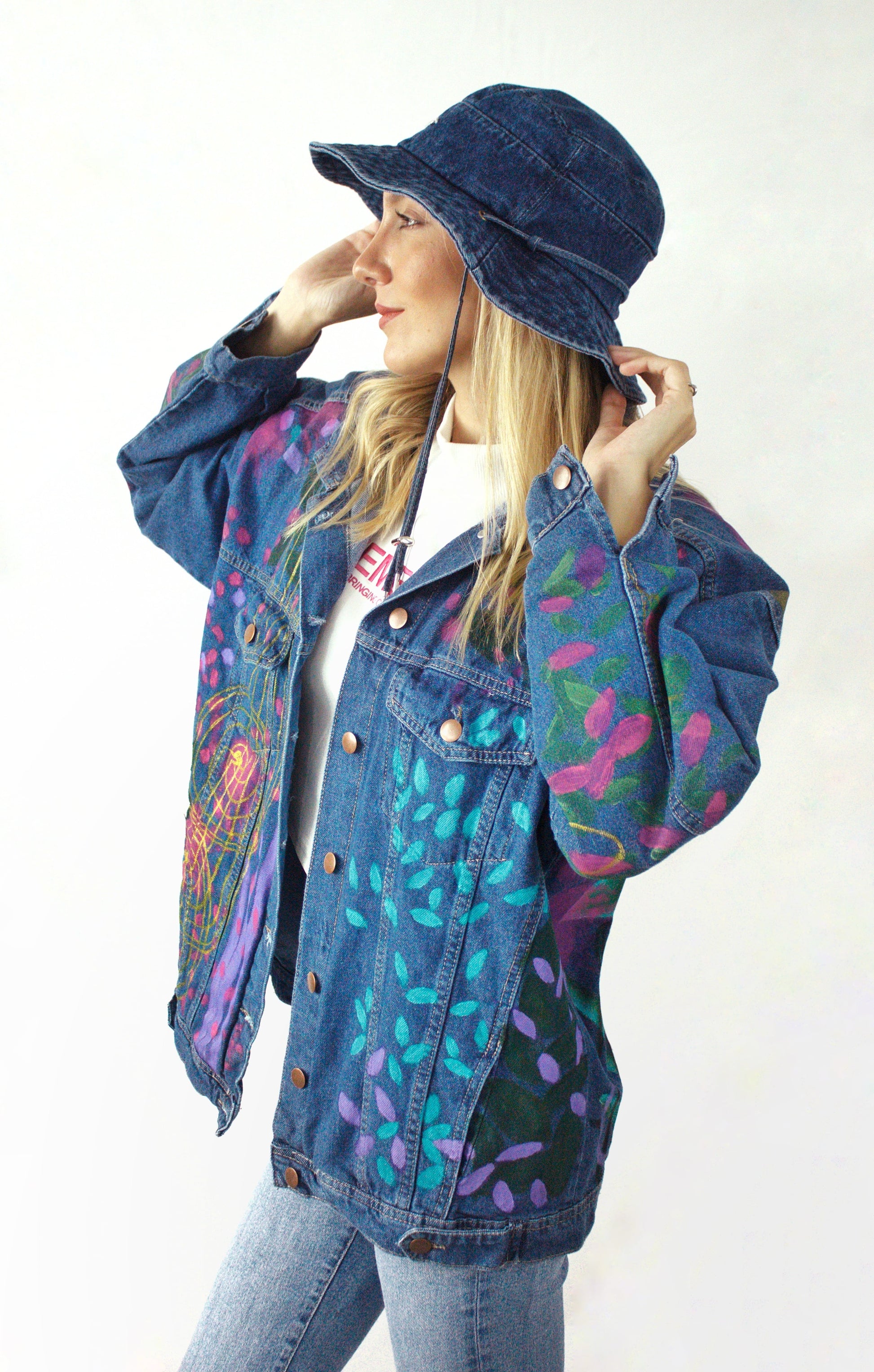 Women’s jean jacket with a handcrafted design of a majestic leopard with bright blue eyes and colorful accents.