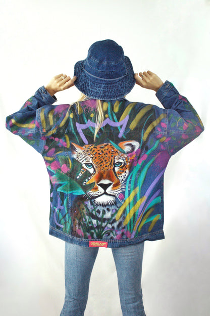 Hand-painted oversized denim jacket for women featuring a crowned leopard and tropical leaves in vibrant colors.